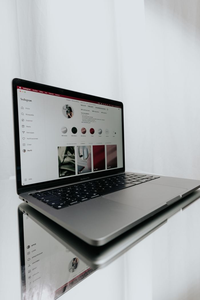 Ordinateur portable élégant affichant un profil Instagram, illustrant la technologie moderne et la connexion en ligne.